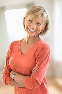 woman in coral sweater smiling