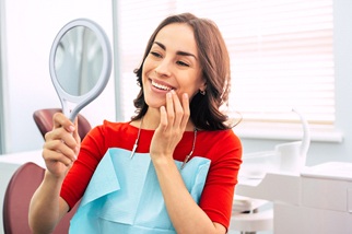 Woman smiling at herself in mirror