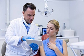 A female patient looking over her chart with her dentist